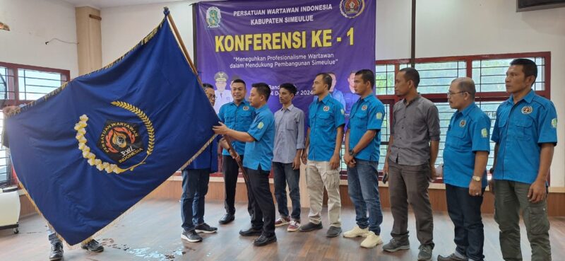 Firnalis menerima bendera pataka PWI seusai dikukuhkan sebagai Ketua PWI Simeulue.