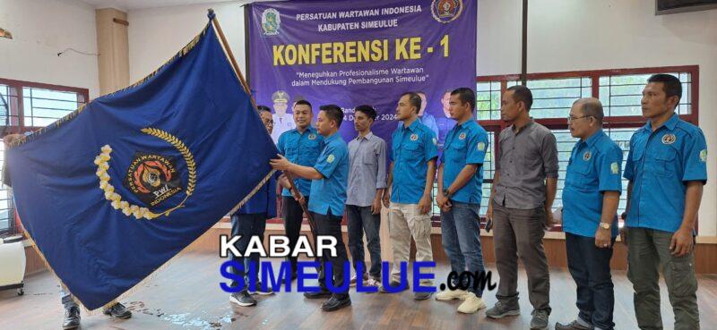 Firnalis menerima bendera pataka PWI seusai dikukuhkan sebagai Ketua PWI Simeulue.