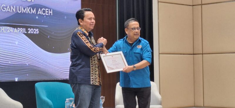 Ketua PWI Aceh, Nasir Nurdin menyerahkan sertifikat penghargaan untuk Regional CEO BSI Aceh, Wachjono pada pembukaan acara Simposium Ekonomi: Kolaborasi PWI-BSI Mendukung UMKM Aceh di Lantai 8 Gedung Landmark BSI Aceh, Kamis, 24 April 2025. (Dok PWI Aceh/Abdul Hadi)