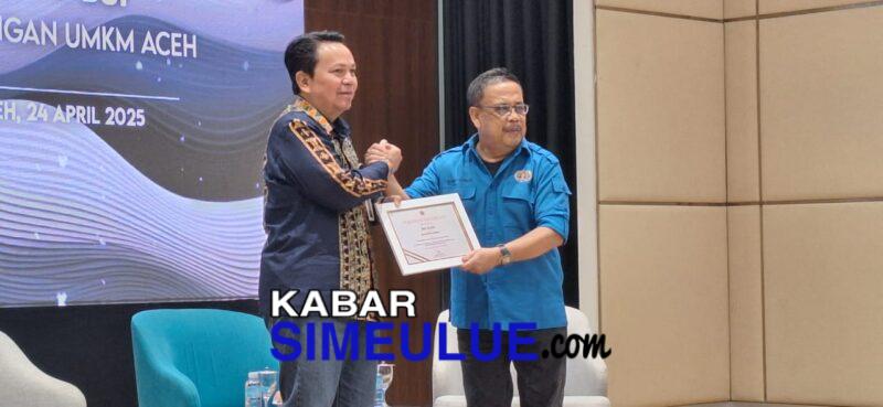 Ketua PWI Aceh, Nasir Nurdin menyerahkan sertifikat penghargaan untuk Regional CEO BSI Aceh, Wachjono pada pembukaan acara Simposium Ekonomi: Kolaborasi PWI-BSI Mendukung UMKM Aceh di Lantai 8 Gedung Landmark BSI Aceh, Kamis, 24 April 2025. (Dok PWI Aceh/Abdul Hadi)